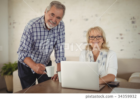 Senior couple using laptop at home 34359932