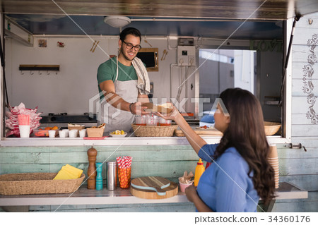 Smiling waiter giving wrap to customer Smiling waiter giving wrap to customer 34360176