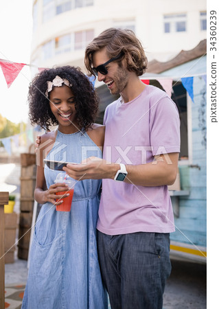 Happy couple using mobile phone Happy couple using mobile phone 34360239