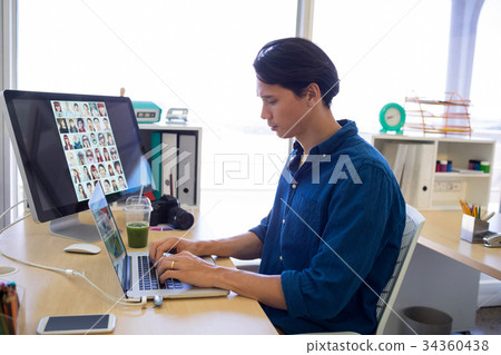 Male executive working over laptop at his desk Male executive working over laptop at his desk 34360438