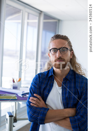 Male architect standing with arms crossed in office Male architect standing with arms crossed in office 34360514