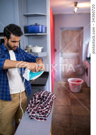 Young man adjusting iron 34360720