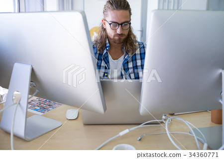 Male executive working over laptop at his desk Male executive working over laptop at his desk 34360771