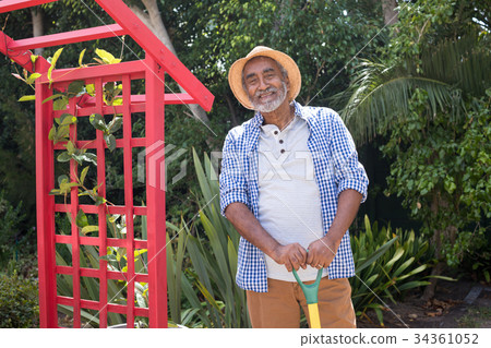 Portrait of smiling senior man holding equipment Portrait of smiling senior man holding equipment 34361052