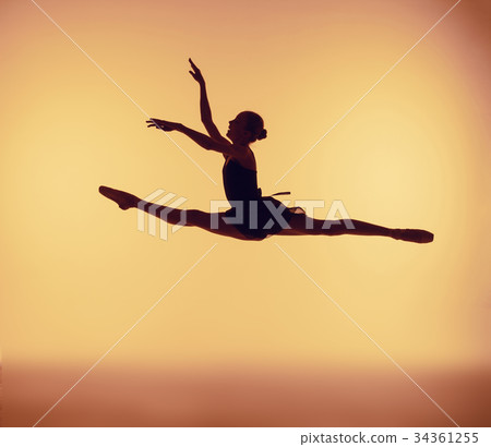 Beautiful young ballet dancer jumping on a orange 34361255