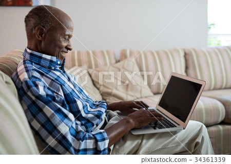 Side view of smiling man using laptop Side view of smiling man using laptop 34361339