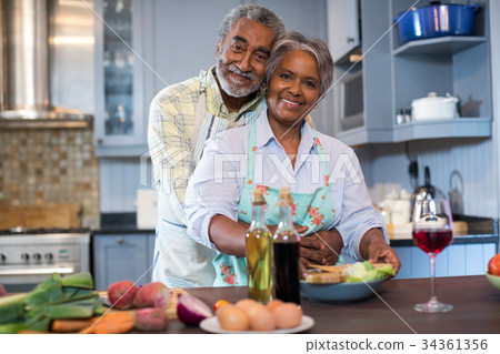 Portriat of smiling senior couple preparing food 34361356