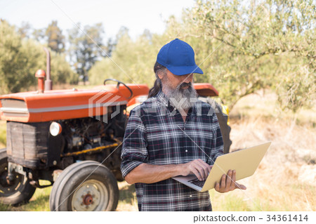 Man using laptop in olive farm 34361414