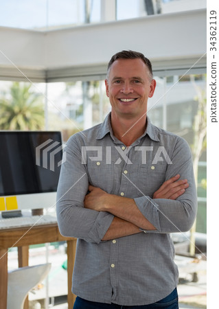 Portrait of confident businessman standing at studio Portrait of confident businessman standing at studio 34362119