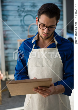 Owner writing menu by food truck 34362156