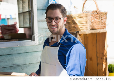 Smiling owner writing menu by food truck 34362170