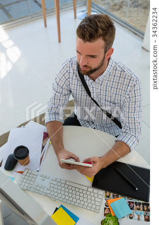 High angle view of graphic designer using tablet computer at desk High angle view of graphic designer using tablet computer at desk 34362234