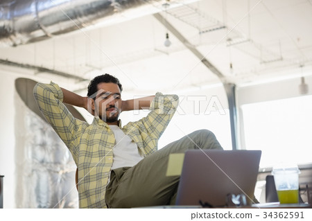 Relaxed man sitting on chair in office Relaxed man sitting on chair in office 34362591