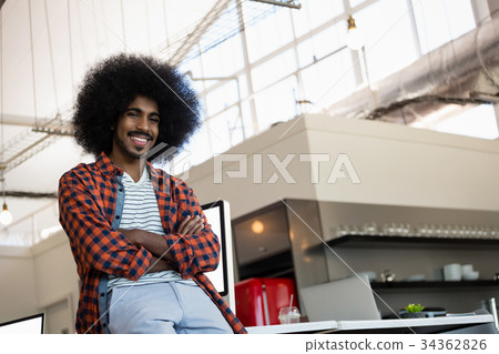 Portrait of smiling man with curly hair at office Portrait of smiling man with curly hair at office 34362826