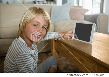 Boy using digital tablet in the living room at home 34363045