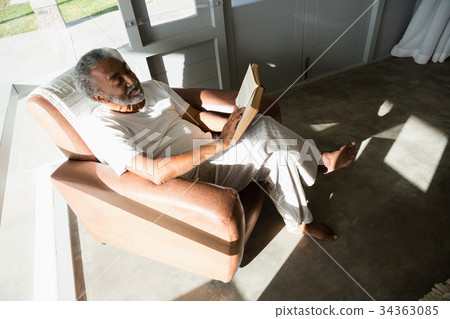 Senior man reading a book at home Senior man reading a book at home 34363085