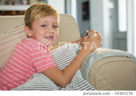 Boy playing video game in the living room at home 34363176