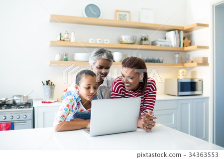 Happy family using laptop in kitchen worktop 34363553