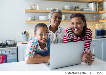 Happy family standing near kitchen worktop with laptop 34363555