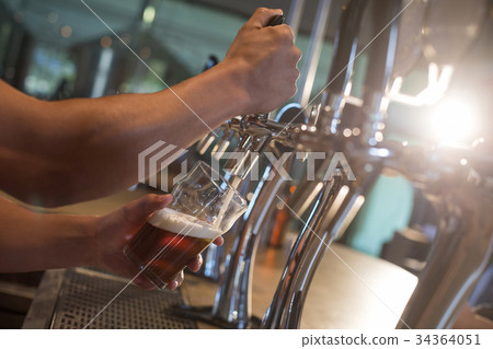 Bartender pouring beer from tap 34364051