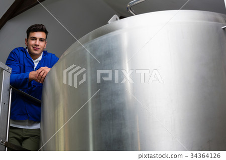 Portrait of young worker by storage tank 34364126