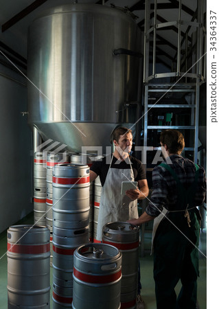 Workers talking while standing at warehouse Workers talking while standing at warehouse 34364337
