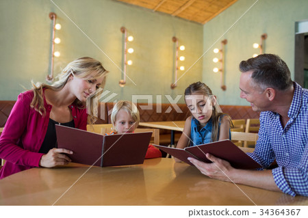 Family reading menu in restaurant 34364367