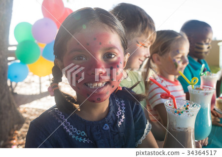 Girl enjoying drinks with friends at park 34364517