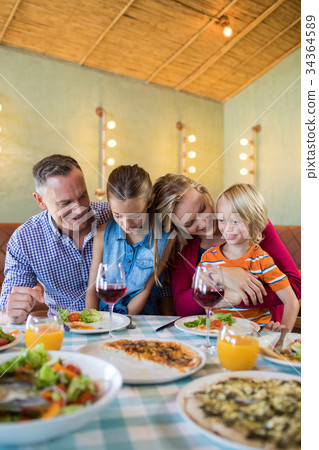 Happy family enjoying dinner at restaurant 34364589