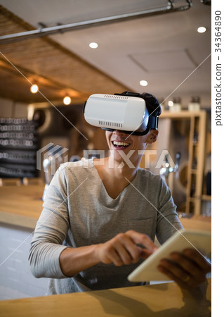 Man using virtual reality headset and digital tablet in restaurant 34364890