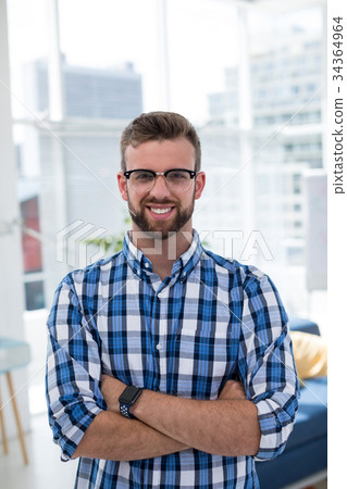 Male executive standing with arms crossed in office 34364964