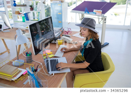 Female executive using laptop and computer 34365296