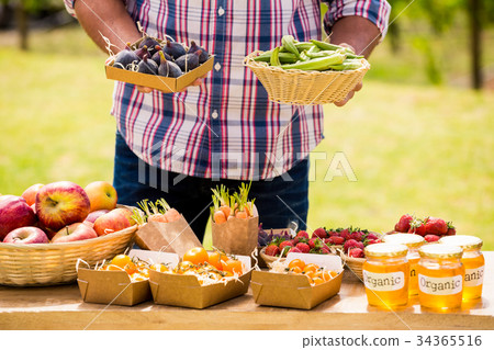 Midsection of man selling figs and okras Midsection of man selling figs and okras 34365516