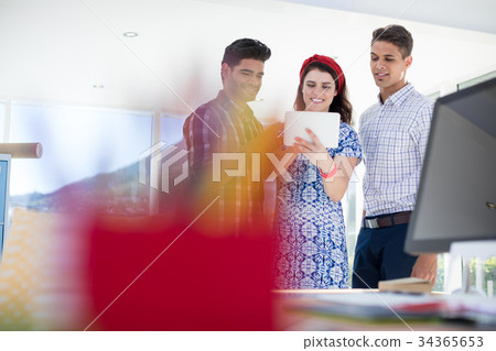 Team of executives discussing over digital tablet 34365653