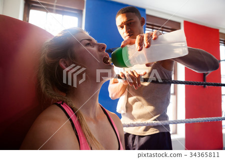 Coach giving water to trainee Coach giving water to trainee 34365811