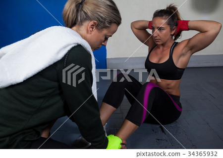 Trainer assisting woman in exercise 34365932