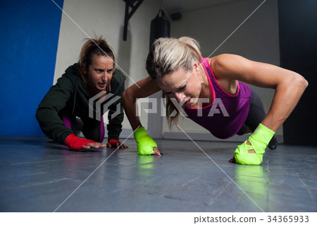 Trainer assisting woman in exercise Trainer assisting woman in exercise 34365933