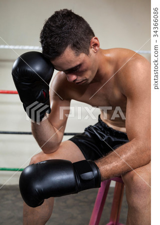 Wounded boxer relaxing in the boxing ring 34366086