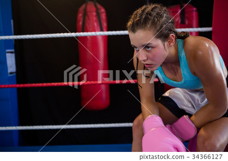 Tired young boxer sitting at corner 34366127