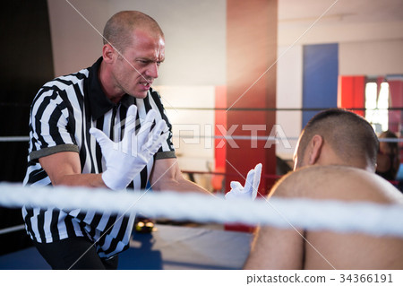 Referee gesturing to male boxer in ring Referee gesturing to male boxer in ring 34366191