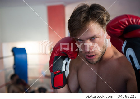 Close-up portrait of young male boxer wearing red gloves 34366223