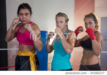Portrait of confident female boxers standing in fighting stance 34366237