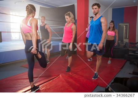 Young athletes stretching legs on exercise mats 34366267