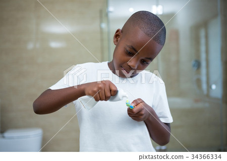 Boy removing toothpaste on brush Boy removing toothpaste on brush 34366334