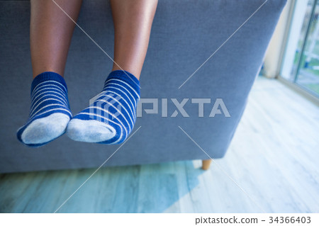 Low section of boy on gray sofa at home 34366403