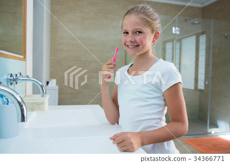 Portrait of girl holding toothbrush 34366771