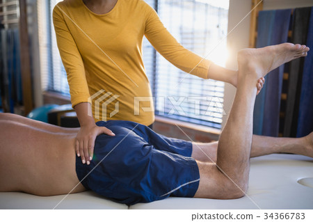 Midsection of female therapist massaging buttocks of senior male patient Midsection of female therapist massaging buttocks of senior male patient 34366783