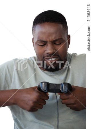 Frustrated man holding joystick against white background 34368448