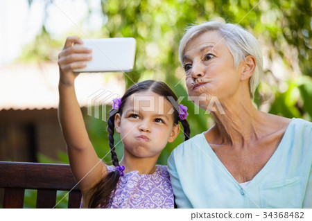 Girl and grandmother making faces while taking selfie Girl and grandmother making faces while taking selfie 34368482