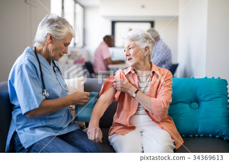 Female doctor checking blood pressure of senior woman Female doctor checking blood pressure of senior woman 34369613